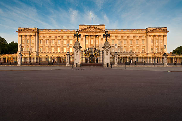 London Buckingham Palace sunrise The Mall UK London, UK - May 3th, 2011: Warm dawn sunlight illuminated the Portland stone facade, windows, balcony and ornate entrance gates of Buckingham Palace, London residence of the British Monarch, from the Victoria Memorial on The Mall. buckingham palace photos stock pictures, royalty-free photos & images