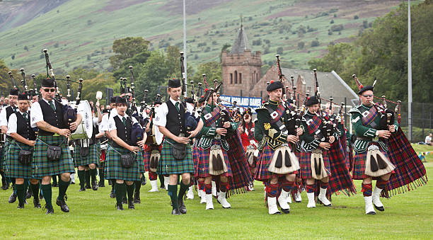 Massed Pipe Bands at Brodick Highland Games, Arran. Brodick, Scotland, UK - August 6, 2011: Massed Pipe Bands, including Maybole Pipe Band, Kilbarchan Pipe Band and the Isle of Arran Pipe Band marching and performing together at Brodick Highland Games, Ormidale Park, Isle of Arran. sporran stock pictures, royalty-free photos & images