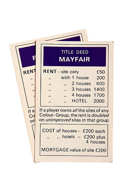Monopoly property cards - Mayfair London, United Kingdom - August 3, 2011: Monopoly game property cards. Monopoly is a board game named after the concept of dominating a market, a monopoly. Players take turns to move around a board buying property and paying and receiving rent. Mayfair stock pictures, royalty-free photos & images