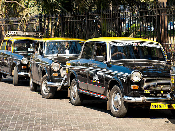 Mumbai, India - January 23, 2008: Row of Old Style black and yellow Taxis wait for passengers in Central Mumbai, India
