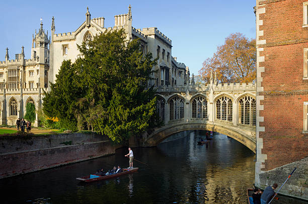 Cambridge, United Kingdom - November 13, 2011: Tourists are enjoying so-called punting, a kind of boat sightseeing, along River Cam in the center of the city of Cambridge, England. The Bridge of Sighs of St John\\'s College is in the middle.