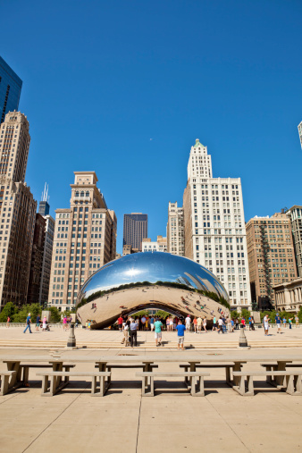 Chicago, USA - August 21, 2011: The stainless steel sculpture named Cloud Gate, created by Anish Kapoor, sits as one of the attractions in Millenium Park. It reflects the skyline and is surrounded by curious tourists looking and taking picture of it and their reflections.