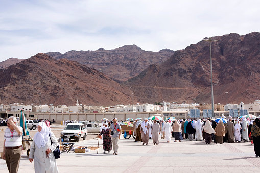 Medina, Saudi Arabia - April 13, 2011: Muslim pilgrims walking around the valley of Mount Uhud and its Mosque . Muslim pilgrims come to this place to pray for the people who lost their lives during the Battle of Uhud which occurred in 625 between a force from the Muslim community of Medina led by the Islamic prophet Muhammad, and a force led by Abu Sufyan who was a staunch opponent of the Islamic prophet Muhammad before accepting Islam later in his life.