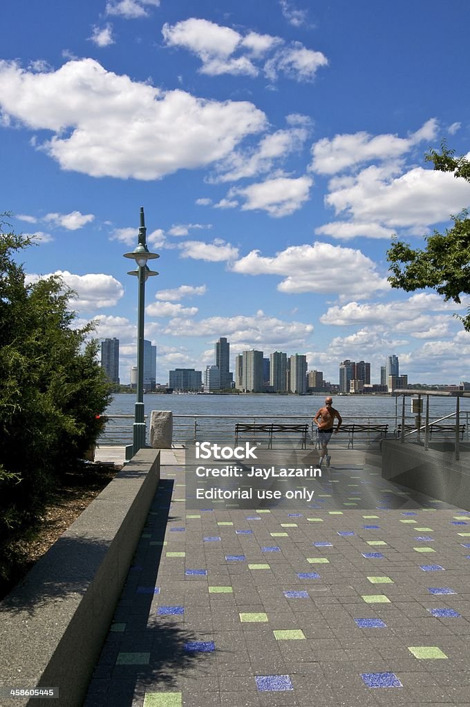 Male Jogger along Hudson River promenade, West Side, Manhattan, NYC New York City, USA - August 11, 2011: A shirtless male is seen jogging along a lower West Side of Manhattan promenade adjacent to the Hudson River. The Jersey City, NJ skyline is seen in the background. New York City Stock Photo