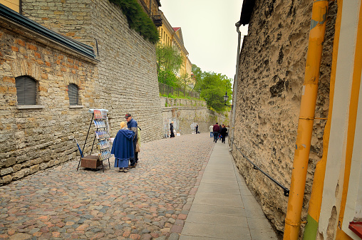 Tallinn, Estonia - May 19, 2011: Vendors line Pikk Jalg street,the main route between the old lower town and the upper area where the royals and elite lived, as tourist look over the offerings and wander up and down the hill.