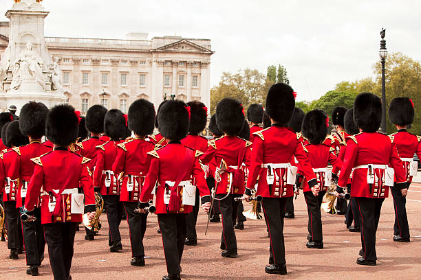 Guardsmen marchando na frente do Palácio de Buckingham, London - foto de acervo