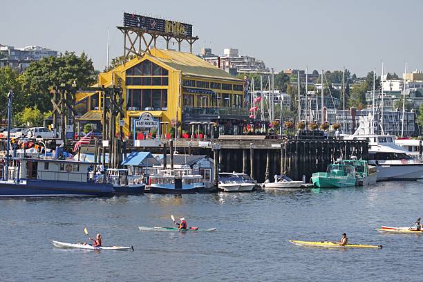 Vancouver's Granville Island and Kayaks in False Creek, Canada, Summer Vancouver, Canada - August 28th, 2011: Granville Island's waterfront is home to restaurants, retail stores, cultural institutions and marinas. False Creek is a popular site for recreational and competitive sports. granville island stock pictures, royalty-free photos & images