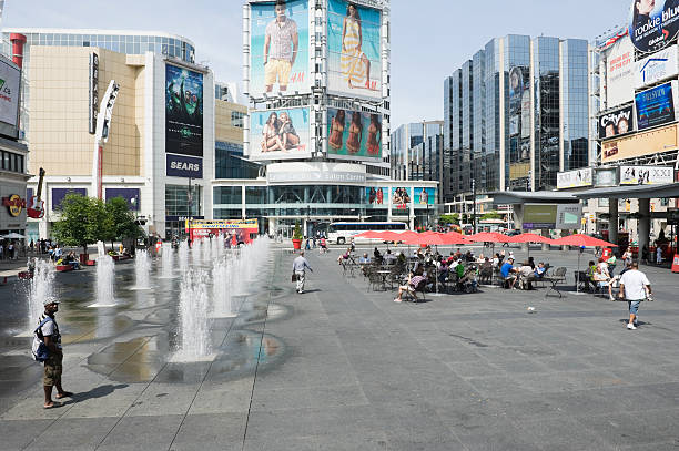 dundas sqaure in downtown Toronto on a sunny summer day TORONTO, Canada - June 27, 2011: dundas sqaure in downtown Toronto on a sunny summer day with lots of people hanging around, sitting and walking toronto dundas square stock pictures, royalty-free photos & images