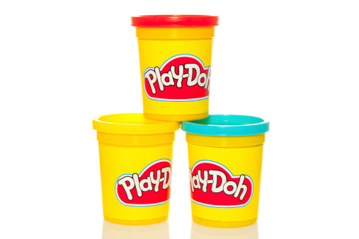 Dublin, Ireland - March 22, 2011: Three tubs of Play-Doh, the popular play-time activity for kids isolated on white bacjground.