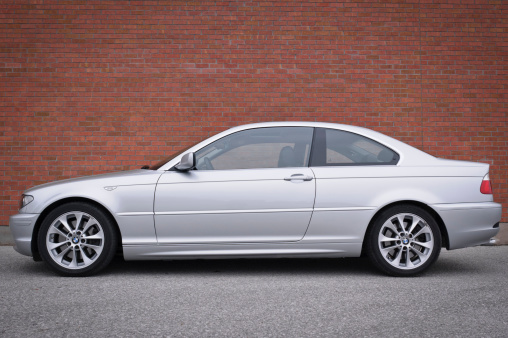 Toronto, ON, Canada - November 12, 2006: BMW 3 Series (E46) coupe in Titanium Silver Metallic parked in front of a brick wall.