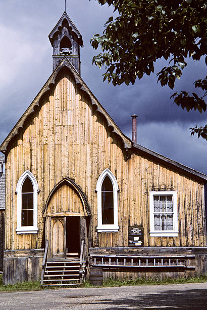 Historic Wooden Church on a Stormy Day Barkerville, British Columbia, Canada - August 27, 1986: Saint Saviour's Anglican Church in the historic mining town of Barkerville, British Columbia was build in 1868. This building contains its original woodwork and is open for daily worship. jeff goulden church stock pictures, royalty-free photos & images