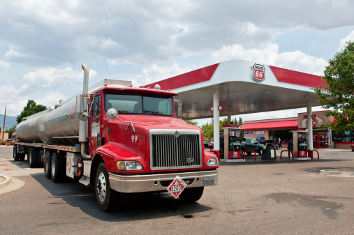 Albuquerque, New Mexico, USA - July 2, 2011: Phillips 66 gasoline and service station with Groendyke semi tanker truck and trailor in North East Albuquerque. Picture taken on partially cloudy day. Groendyke operates a large fleet of tank truck carriers that transport chemical, petroleum, and grain products from coast to coast, and to Mexico and Canada.