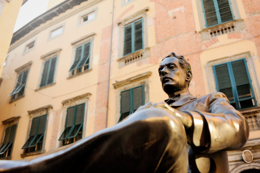 Lucca, Italy - June 27, 2011: The bronze statue of Giacomo Puccini asserts its presence in front of the Italian composer's birthplace in Lucca, Italy. Puccini composed, among others, the operas La Boheme, Tosca, and Madame Butterfly.