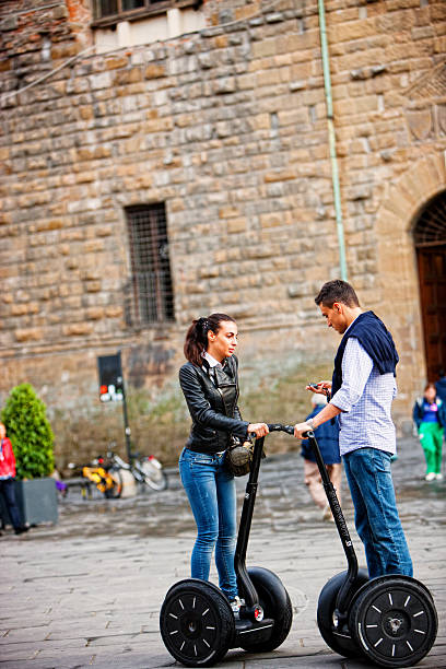 giovane coppia in viaggio con il segway, firenze, italia - segway young couple outdoors young adult foto e immagini stock