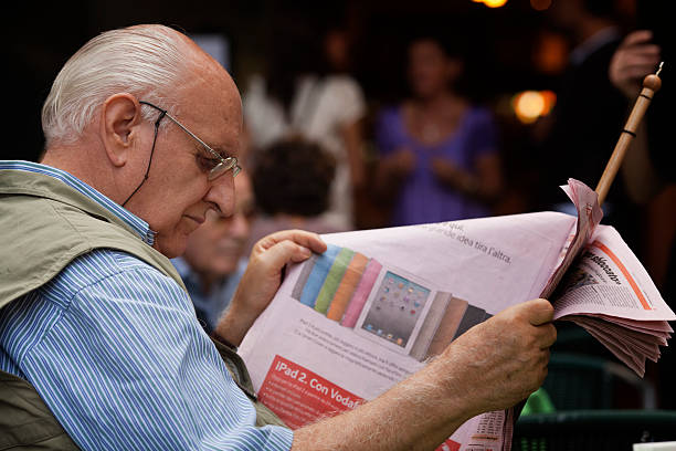 senior man reading an italian newspaper stock photo
