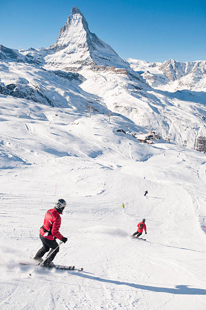 Zermatt, Switzerland - 15th January 2011: People skiing down a piste at the Swiss ski resort of Zermatt, with the peak of the Matterhorn visible in the background.