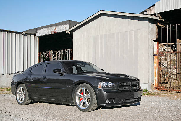 Dodge Charger "Nashville, Tennessee, USA - November, 22nd 2006: A black Dodge Charger SRT-8 model sports car in front of an industrial building." dodge charger stock pictures, royalty-free photos & images