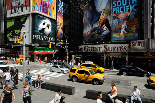 New York, United States-May 2009: Entertainment, show and musical area on time square with colorful billboards and posters show on a clear sunny day