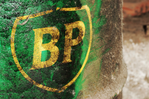 Celje, Slovenia - April 19, 2012: Old British Petroleum logo on a green barrel covered by oil. British Petroleum is third largest energy company in the world. BP was involved in many major environmental incidents including Deepwater Horizon oil spill which was the largest oil spill to date in petroleum industry. This shield style logo was used since 2002.