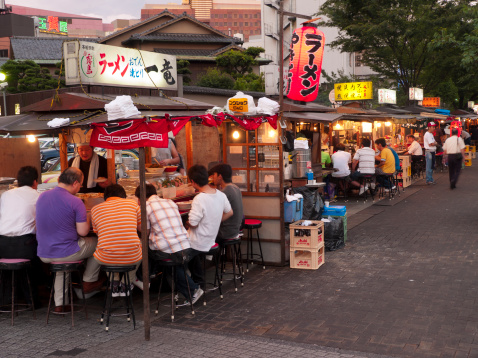 Fukuoka, Japan - June 28, 2007: Traditional Japanese streetside food stalls. People can be seen sitting inside these eating and drinking.