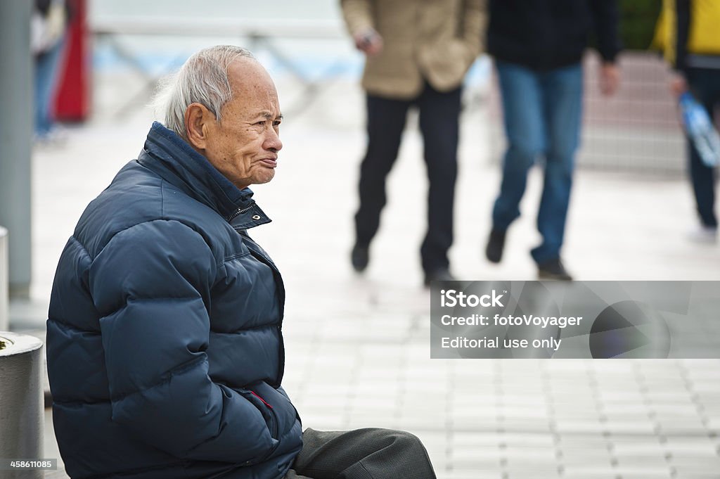 Älterer chinesische Mann sitzt auf der promenade Hong Kong - Lizenzfrei Hongkong Stock-Foto