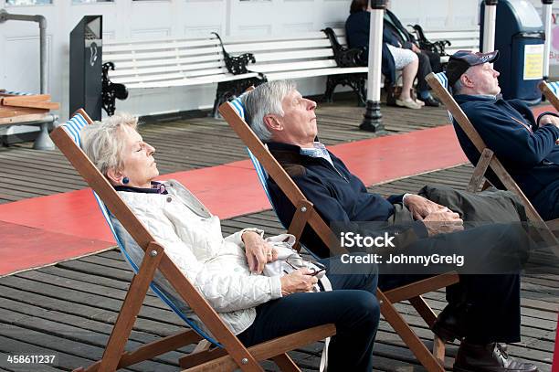 Anziani Dormire In Sedie A Sdraio Sul Molo Di Brighton - Fotografie stock e altre immagini di Ambientazione esterna