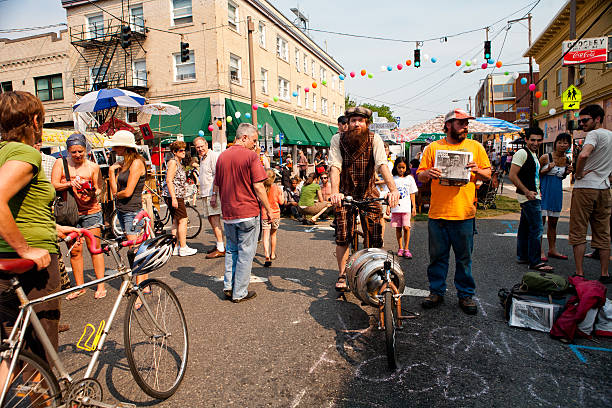 Portland, Oregon, USA - September 10, 2011: People crowd Belmont Street in southeast Portland for the annual Belmont street fair.  A man with a modified bicycle to haul a beer keg rides through the crowd.