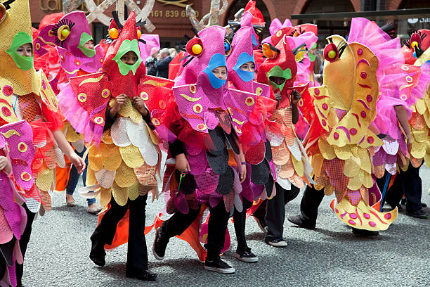 Manchester, UK - June 19, 2011: Children and adults dressed in colourful fish costumes, taking part in the Manchester Day Parade. The annual parade celebrates the cultural diversity of the city.