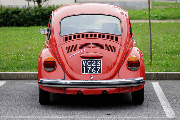 alte rote vw käfer auf der straße - car rear view behind car trunk stock-fotos und bilder