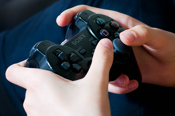 Playstation wireless controller Bassano del Grappa, Italy - June, 07, 2012: Young girl's hands holding playstation wireless controller (gamepad) brand name games console stock pictures, royalty-free photos & images