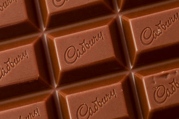 cadbury dairy milk chocolate bar London, England - March 2, 2011: The Cadbury Dairy Milk chocolate bar was first produced in the UK in 1905 and had more milk content than its competitors. It became the top seller for Cadbury. cadbury plc photos stock pictures, royalty-free photos & images