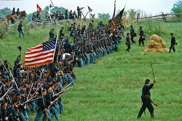 Huntington Beach CA USA - August 31, 2024: Confederate flag held high during a reenactment battle with smoke from the battle surrounding the troops, the Huntington Beach Historical Society hosts, the 31st annual Civil War Days, a reenactment of the Civil War at Huntington Beach Central Park.