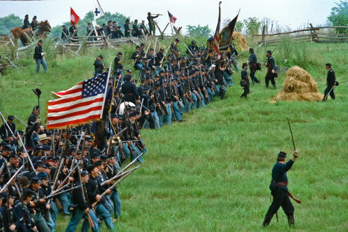 Frederick, USA - July 22,1989:  A formation of Union infantry in line of battle moves forward to attack a Confederate position in a reenactment of the Battle of Monacacy in Maryland.  This particular battle, which was technically a Union loss, delayed Confederate forces in their planned attack on Washington, DC long enough for reinforcements to arrived and save the capitol.