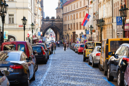 Prague, Czech Republic - September 30, 2011: Mostecka Street. Dense row of cars parked along the street. Tourists visible in the background.