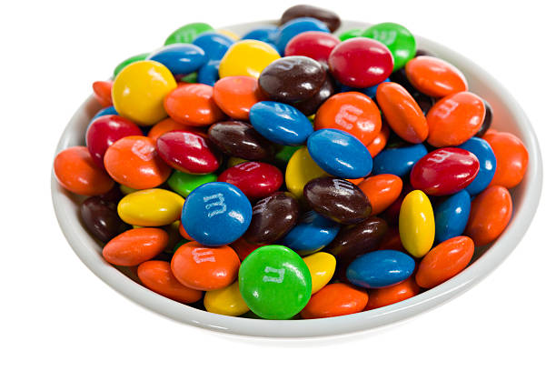 Bowl Of m&m's. Chico, California, USA - March 06, 2011 : A white bowl choke full of multicolored m&m candies. m&m\'s made their debut in 1941 and were intended for the GI\'s in WW2, they were originally packaged in tubular containers, it wasn\'t until 1948 that they started appearing in the familiar brown package.m&m\'s are named after their creators Mars & Murry. m&m\'s are a brand of the Mars Corporation. M&M stock pictures, royalty-free photos & images