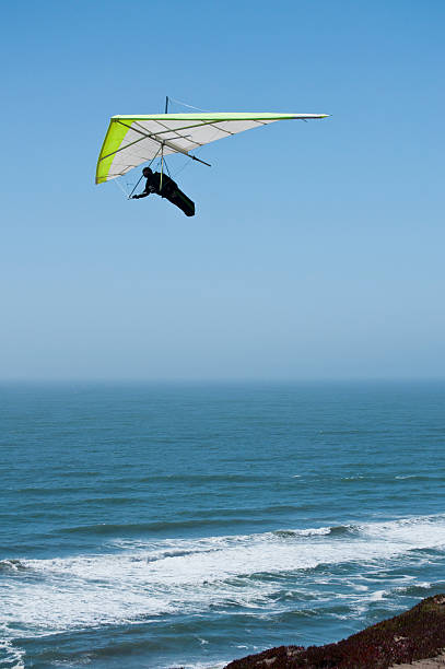 Hang glider soaring over ocean "San Francisco, USA - June 19, 2011: Hang glider soaring over ocean" glider hang glider hanging sky stock pictures, royalty-free photos & images