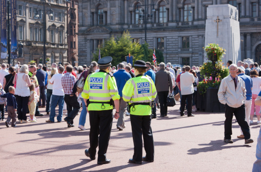 Glasgow, UK - July 2, 2011: Two members of  Strathclyde Police Force's Anti-Sectarian Initiative monitor crowds on George Square, Glasgow during an Orange Order parade celebrating the 17th century victory of the protestant King William of Orange over the catholic King James Stuart ot the Battle of the Boyne.