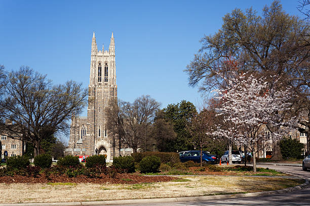 Historic Duke University campus in the spring Durham, USA - March 18, 2011: Duke University Chapel and it's imposing bell tower in the morning with few undergraduate students walking to class at another part of the campus on one of the warmer days of spring. duke photos stock pictures, royalty-free photos & images