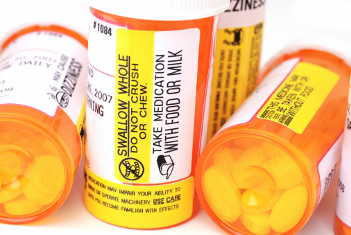 Sterling, Virginia, USA - August 22, 2007: This is a product shot of several prescription pill bottles with warning and instruction labels. Pills are visible through the semi transparent plastic. Some of the labels include: Swallow Whole, Take Medication with Food, May Cause Dizziness, May Impair Ability to Drive.