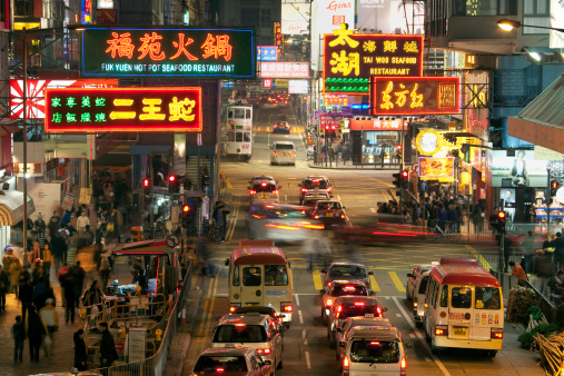 Hong Kong, China - March 11, 2011: Street Scene in Mongkok. Colorful shopping street Illuminated at night. Mongkok is a district in Hong Kong and has the highest population density in the world