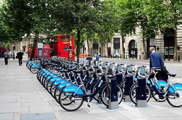 'Boris Bikes' in The Strand, London London, England - August 10, 2011: A row of 'Boris Bikes', as they are affectionately known, parked in The Strand, London. The Mayor of London, Boris Johnson, has introduced a cycle-hire scheme in conjunction with Barclay's Bank, to encourage people to cycle in London instead of using their cars, thereby reducing traffic congestion, pollution and parking problems. Around 6,000 bikes are stored at 400 docking stations like this one.People visible in the image. boris bus stock pictures, royalty-free photos & images