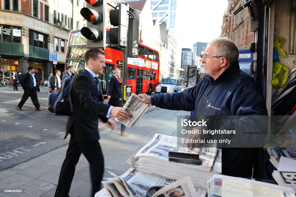 Businessman gets a free newspaper in London London, UK - May 03, 2011: A businessman gets a London Evening Standard newspaper from a news dealer located in front of Liverpool Street Station. London Evening Standard is a free local daily newspaper. UK Stock Photo