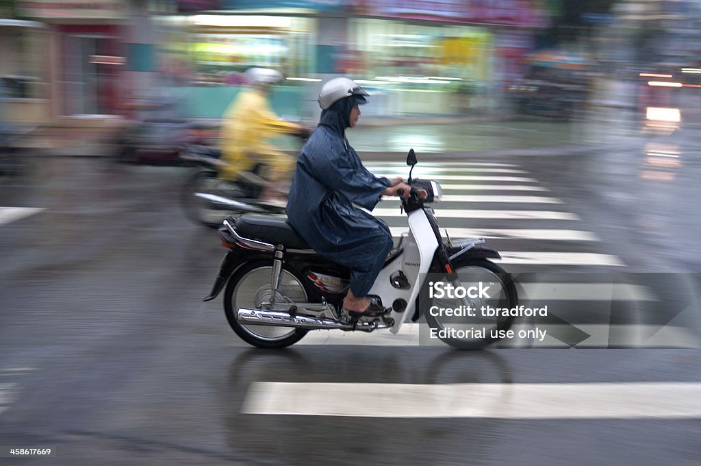 Motorcycling Through A Storm In Vietnam Nha Trang, Vietnam - January, 19 2010: People riding motorcycles through a heavy rain shower in Nha Trang. Motorcycles are a common form of transport in Vietnam and are ridden in all kinds of weather Asia Stock Photo