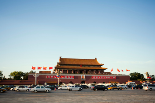 Beijing, China - September 27, 2010: Traffic at the Tiananmen Square. A picture of Chairman Mao Zedong hangs above the entrance to the Forbidden City.