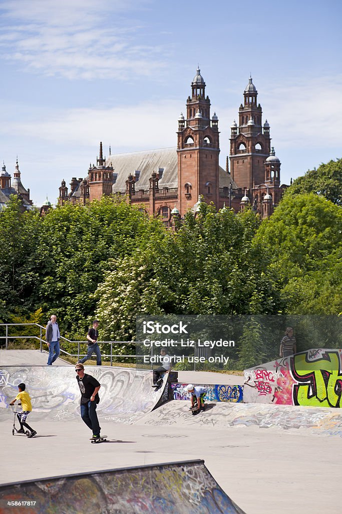 Skatepark in Kelvingrove Park, Glasgow; Museum/Art Gallery behind. Glasgow, Scotland, UK - 20th June 2010: Young men and boys at the graffitied skateboard park within Kelvingrove Park in the West End of Glasgow. Kelvingrove Museum and Art Gallery is in the background, behind the trees. Kelvingrove Art Gallery and Museum Stock Photo
