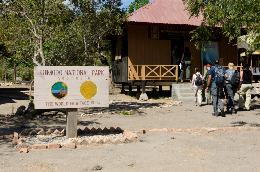 Komodo, Indonesia - August 10, 2011: Group of tourists are entering the Komodo National Park in Indonesia. Komodo is one of the two major islands to spot the famous Komodo Dragon. The other one is Rinca Island.