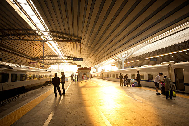 Beijing, China - October 07, 2009: Passengers get off the High-Speed trains arriving at Beijing West Railway Station. Early morning sun is illuminating the station.