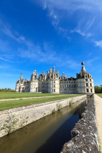 Chambord, France - August 18, 2015: Panoramic  view of Chambord Castle from the river. Built as a hunting lodge for King Francois I, between 1519 and 1539, this castle is the largest and most frequented of the Loire Valley.