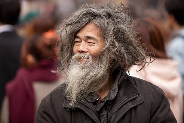 Tokyo, Japan - November 4th, 2010 : A homeless Japanese man walks through a crowded street enjoying the sun.