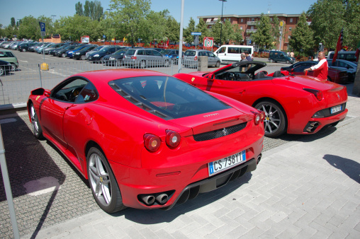 Maranello, Italy - May 26, 2010: Rear ends of two red Ferraris: F430 and California parked near Ferrari Museum at Maranello, Italy. There are many test drive points around that area where you can rent and drive variuos sports cars, mostly Ferarris. These two were also ready for a test drive.